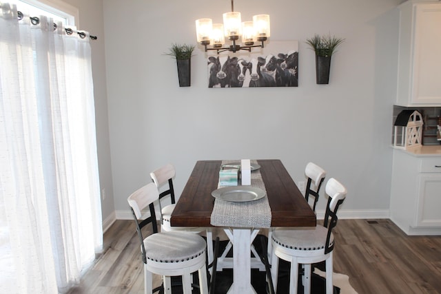 dining room with baseboards, dark wood finished floors, and a notable chandelier