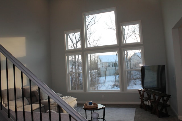 staircase featuring a high ceiling and baseboards