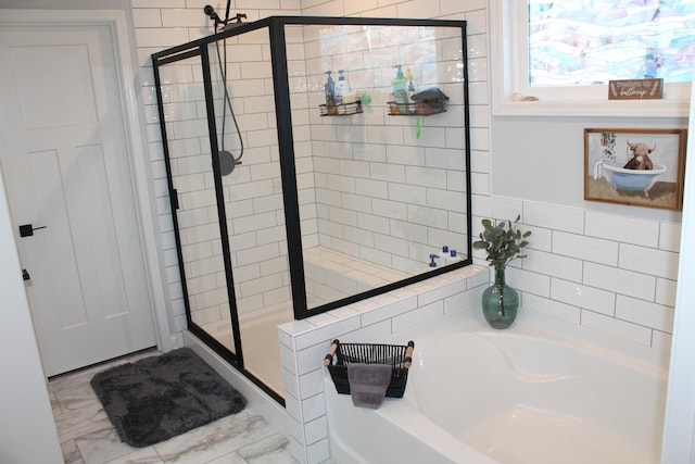 full bath with marble finish floor, a garden tub, and a shower stall