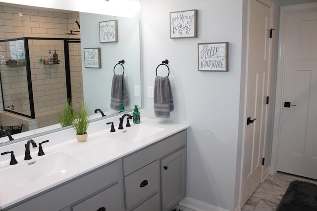 bathroom featuring marble finish floor, a sink, baseboards, and double vanity