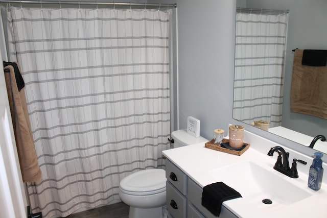 bathroom featuring curtained shower, vanity, and toilet