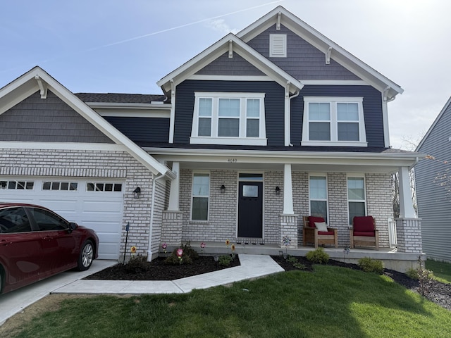 craftsman inspired home with an attached garage, a front yard, and covered porch