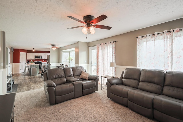 living room featuring a textured ceiling and ceiling fan