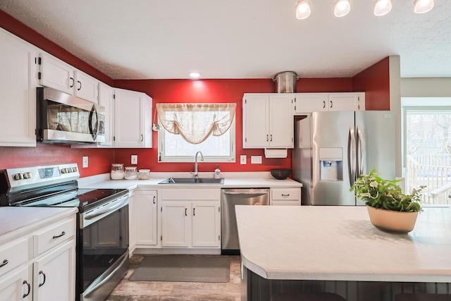 kitchen featuring appliances with stainless steel finishes, light countertops, and a sink