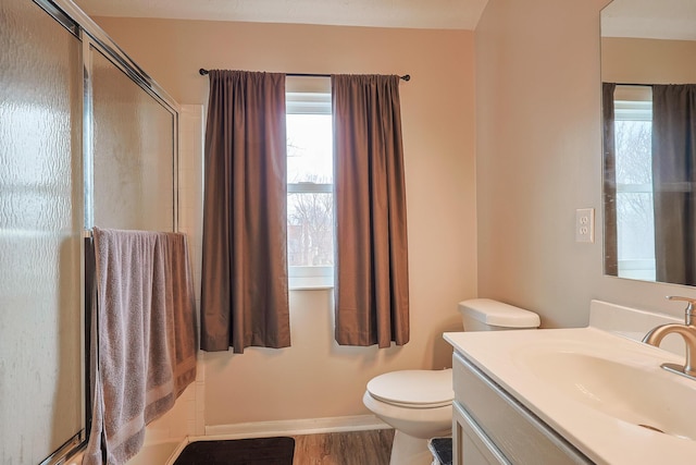 full bath featuring a stall shower, baseboards, toilet, wood finished floors, and vanity