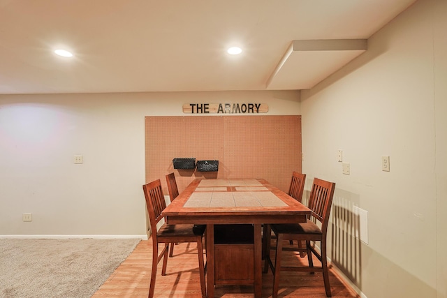 dining room with baseboards, wood finished floors, and recessed lighting