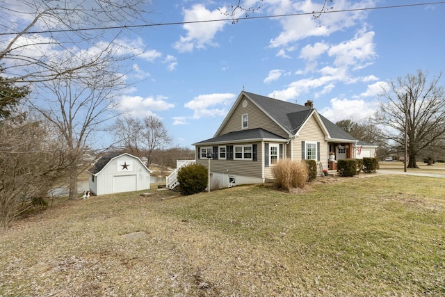 view of home's exterior with a chimney, a detached garage, roof with shingles, an outbuilding, and a yard