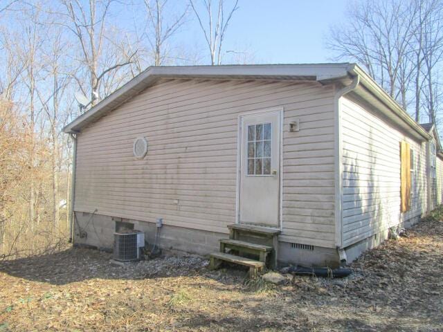 view of side of home featuring entry steps, crawl space, and central air condition unit