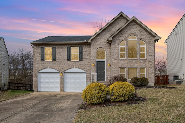 view of front of home with a garage, concrete driveway, fence, a yard, and brick siding