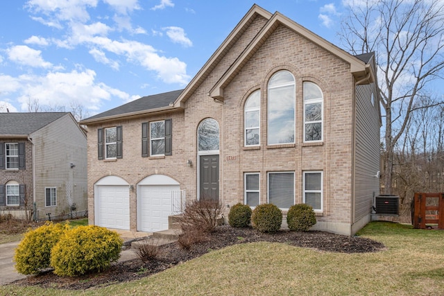 bi-level home with brick siding, central AC unit, a garage, driveway, and a front lawn