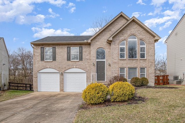 raised ranch with brick siding, concrete driveway, fence, a garage, and a front lawn