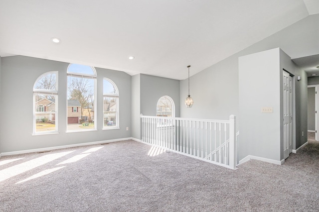 carpeted spare room featuring recessed lighting, visible vents, vaulted ceiling, and baseboards