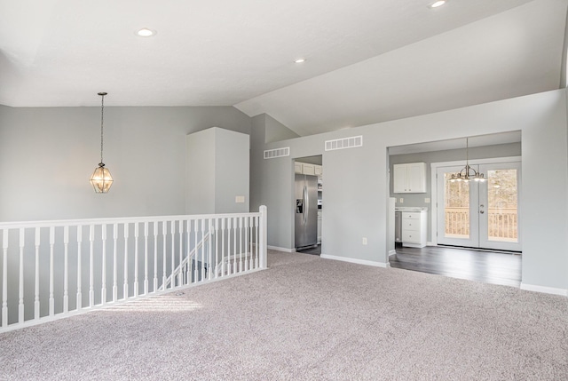 empty room with lofted ceiling, visible vents, and baseboards