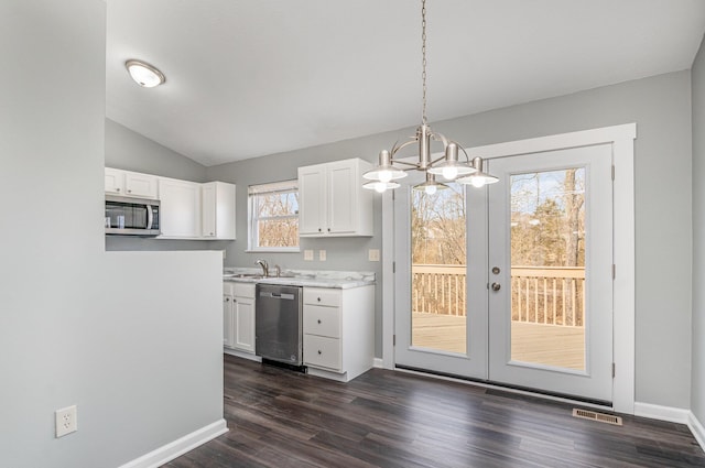 kitchen with visible vents, white cabinets, light countertops, appliances with stainless steel finishes, and hanging light fixtures