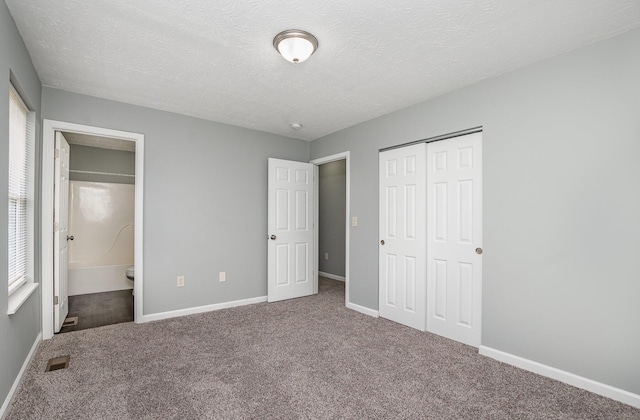 unfurnished bedroom with carpet floors, a closet, visible vents, and baseboards