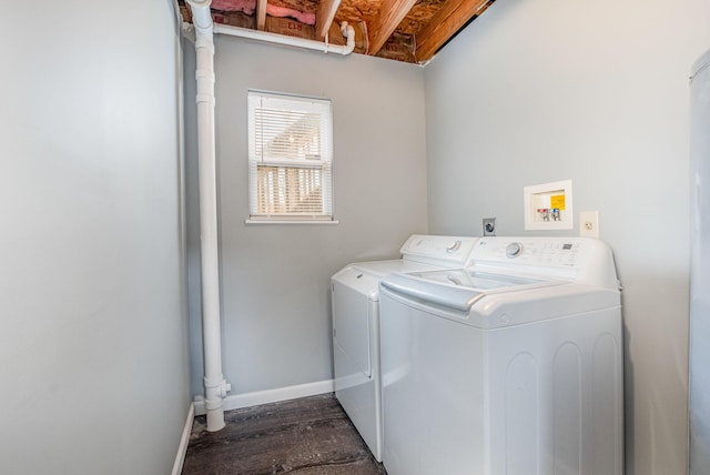 washroom featuring washing machine and dryer, laundry area, dark wood finished floors, and baseboards