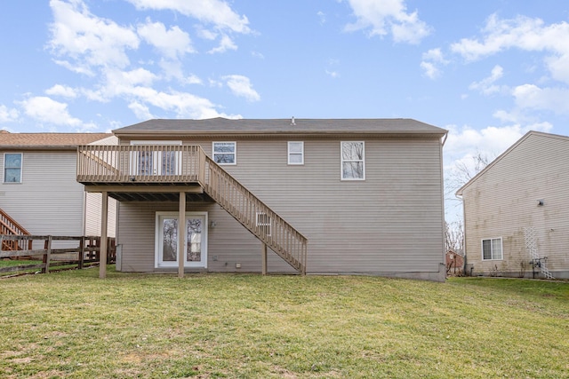 back of property with a lawn, stairway, a wooden deck, and fence