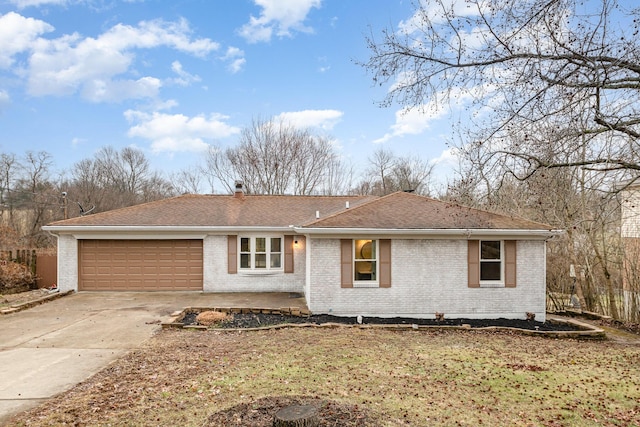 single story home with brick siding, a chimney, a shingled roof, concrete driveway, and a garage