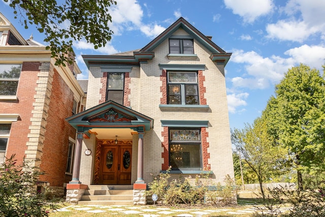 victorian home featuring brick siding