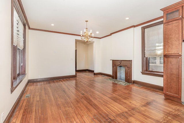 unfurnished living room with a notable chandelier, a fireplace with flush hearth, baseboards, wood-type flooring, and crown molding