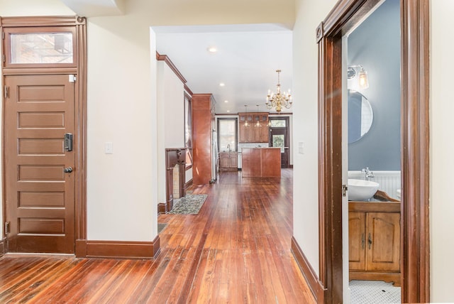 foyer entrance with recessed lighting, baseboards, an inviting chandelier, and hardwood / wood-style flooring