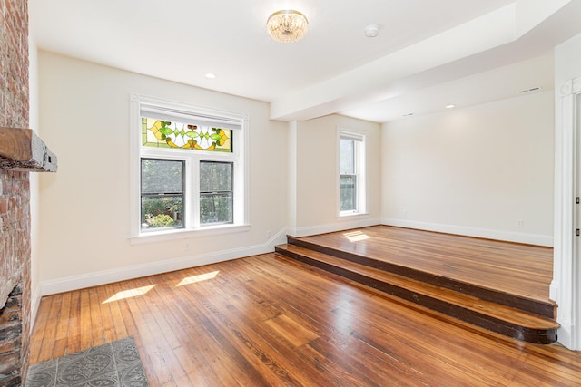 unfurnished living room featuring baseboards and hardwood / wood-style floors