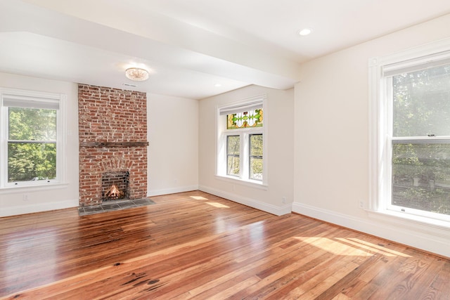 unfurnished living room with recessed lighting, a brick fireplace, baseboards, and hardwood / wood-style flooring