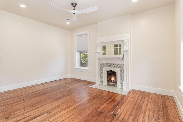 unfurnished living room with a fireplace, recessed lighting, a ceiling fan, baseboards, and hardwood / wood-style flooring