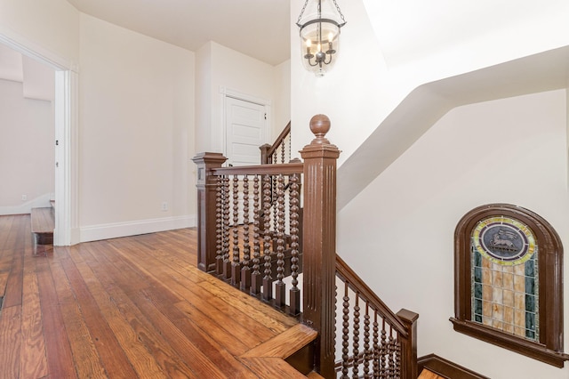 interior space with baseboards, a notable chandelier, and hardwood / wood-style floors