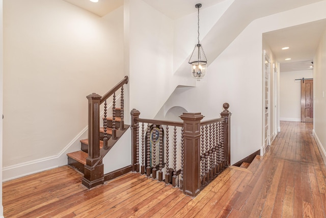 stairs with baseboards, hardwood / wood-style floors, and a barn door