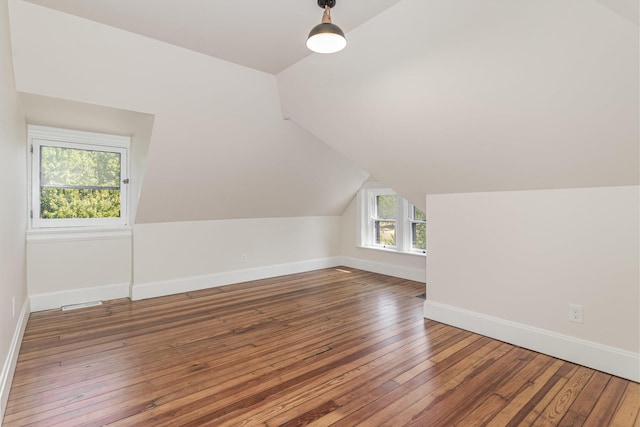 additional living space with lofted ceiling, baseboards, and hardwood / wood-style flooring