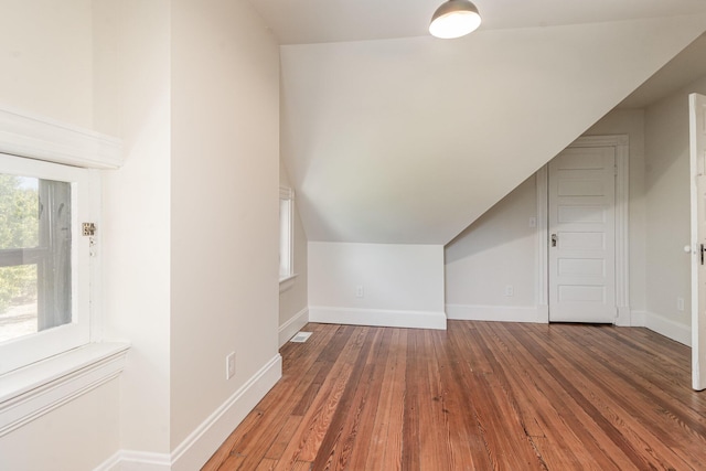 bonus room with baseboards, vaulted ceiling, and wood finished floors