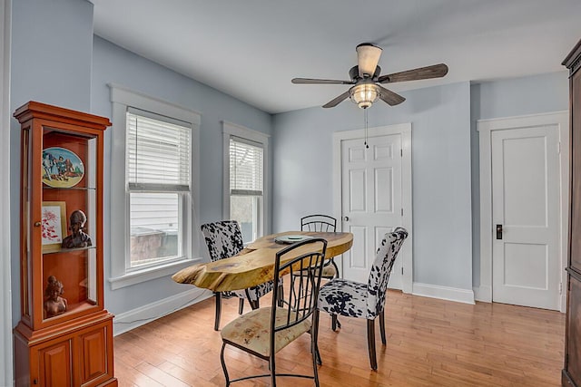 dining space featuring light wood-style flooring, baseboards, and ceiling fan