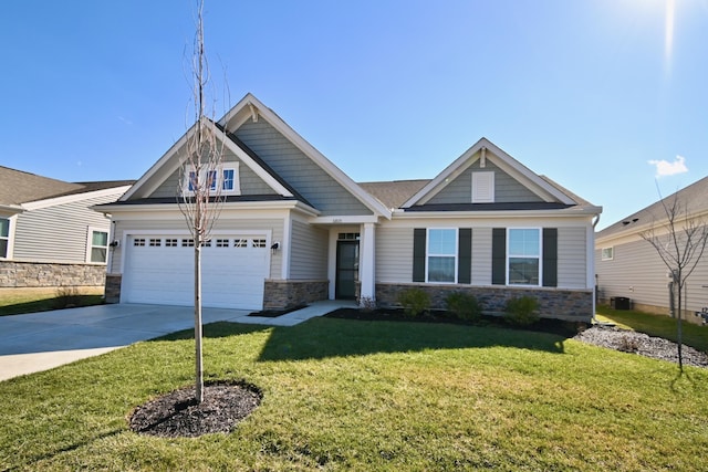 craftsman inspired home featuring driveway, stone siding, a garage, and a front lawn