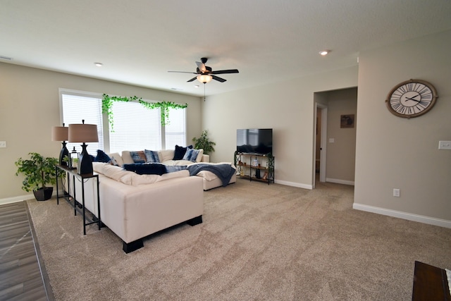 living room featuring light carpet, ceiling fan, baseboards, and recessed lighting