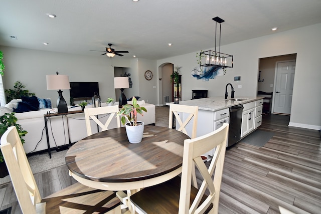 dining space featuring recessed lighting, visible vents, arched walkways, wood finished floors, and ceiling fan with notable chandelier