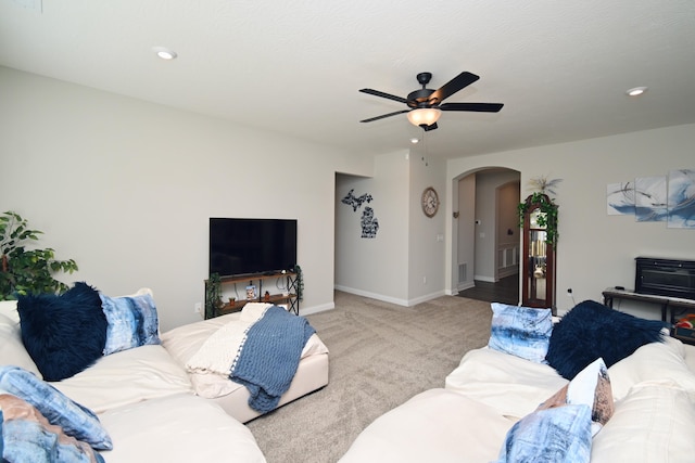 living room with arched walkways, recessed lighting, light carpet, a ceiling fan, and baseboards