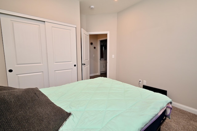 carpeted bedroom with a closet and baseboards