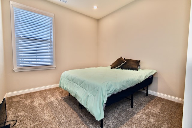 bedroom with visible vents, dark carpet, and baseboards