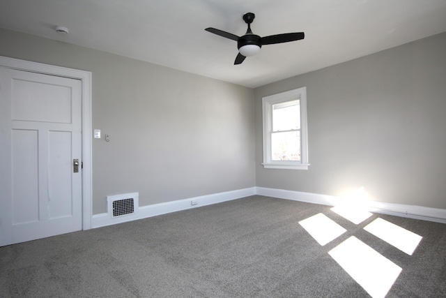 carpeted spare room featuring baseboards, visible vents, and a ceiling fan