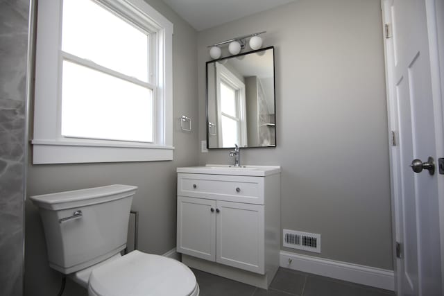 bathroom with toilet, vanity, visible vents, baseboards, and tile patterned floors