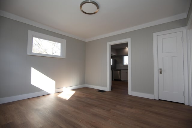 interior space featuring ornamental molding, dark wood-style flooring, connected bathroom, and baseboards