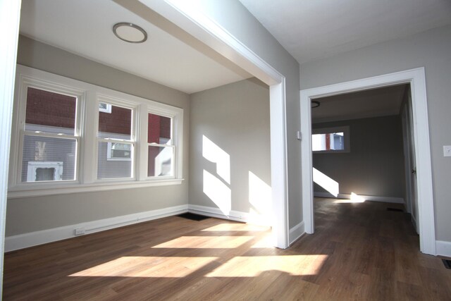 unfurnished room featuring baseboards and wood finished floors