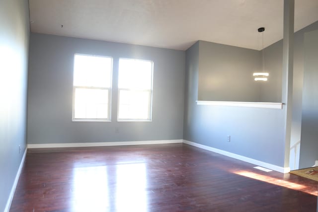 spare room featuring wood finished floors and baseboards