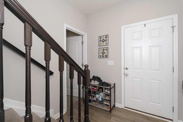 entryway with stairway, baseboards, and wood finished floors