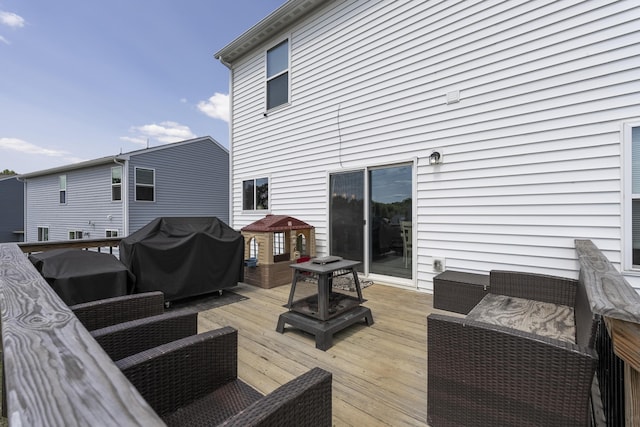 wooden deck with grilling area and an outdoor living space with a fire pit