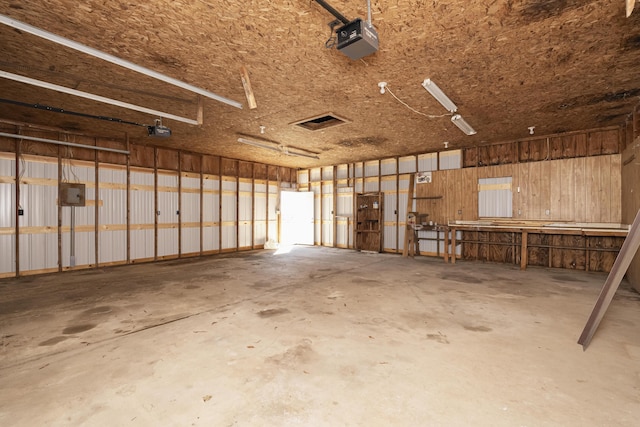 garage featuring electric panel and a garage door opener