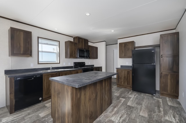 kitchen with dark countertops, a center island, dark wood-style flooring, and black appliances