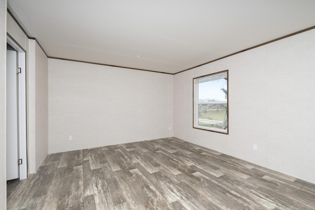 unfurnished room with crown molding and wood finished floors