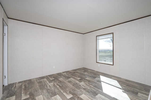 empty room featuring crown molding and wood finished floors